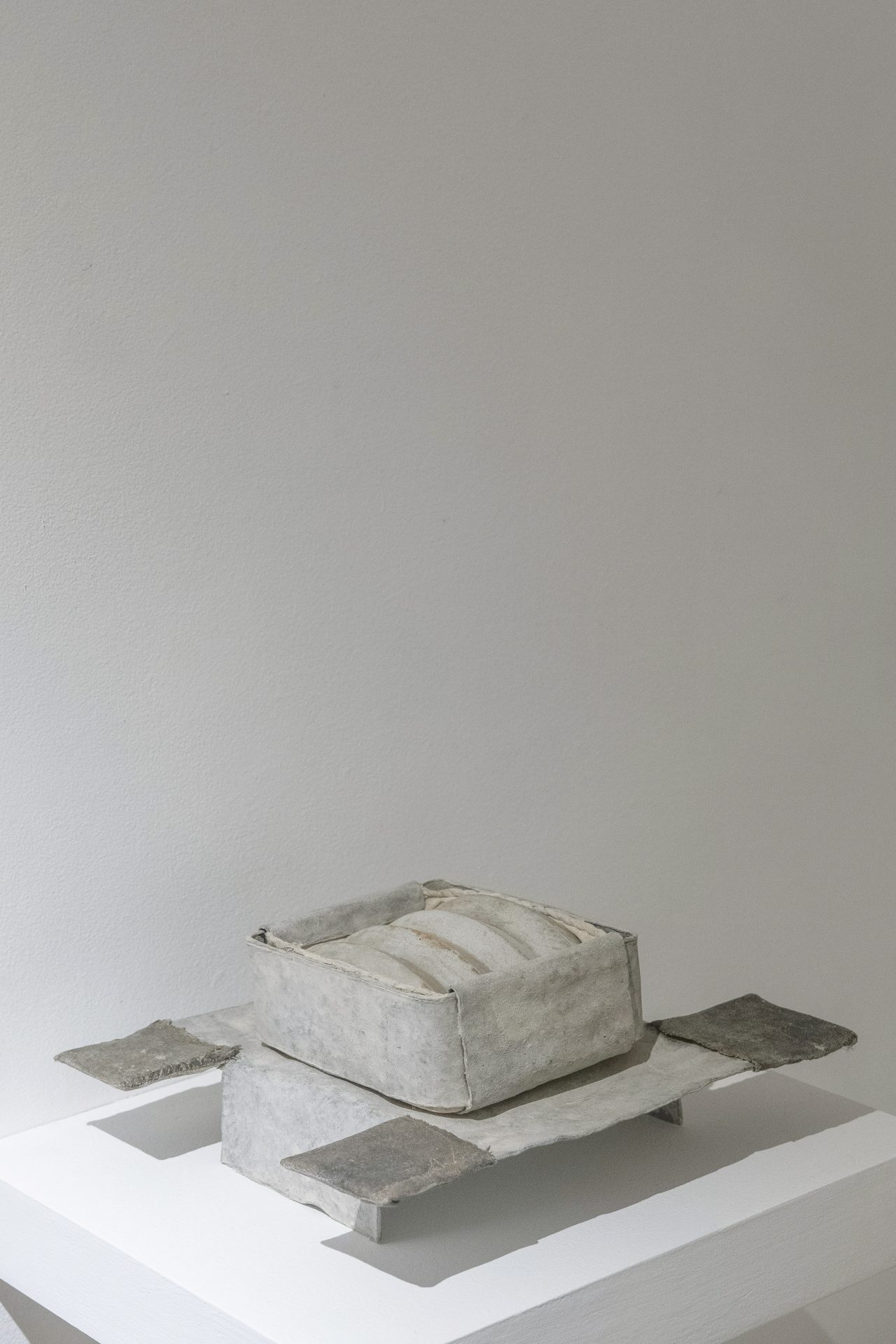 Reliquary . Artwork sculpture by Jamie Mills made from lead, wool, cotton, chalk distemper, thread, filler, (form cast from vintage barquette mould) . 10.5 x 21 x 24.5 cm